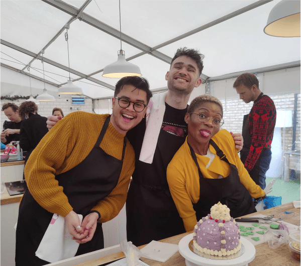Three of the team baking a cake together